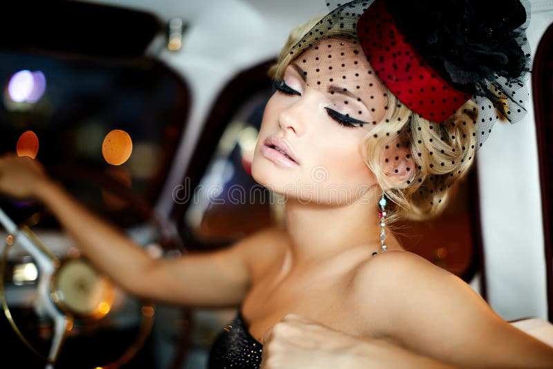 Arbeiten Sie blondes Modell im Retrostil im alten Auto um stockfotografie Arbeiten Sie blondes Modell im Retrostil im alten Auto um stockfotografie