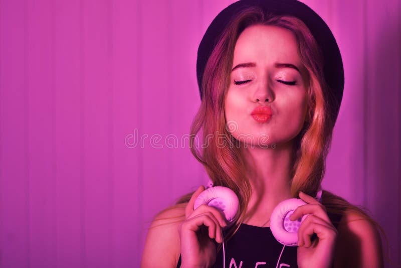 Arbeiten Sie das recht kühle Mädchen in den Kopfhörern hörend Musik über rosa Hintergrund um Energiemodell mit dem langen Haar Mi stockfoto Arbeiten Sie das recht kühle Mädchen in den Kopfhörern hörend Musik über rosa Hintergrund um Energiemodell mit dem langen Haar Mi stockfoto