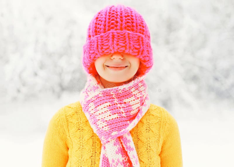 Arbeiten Sie die glückliche lächelnde Frau des Winters um, welche die bunte Strickmütze trägt, die Spaß über schneebedecktem hat lizenzfreie stockfotografie