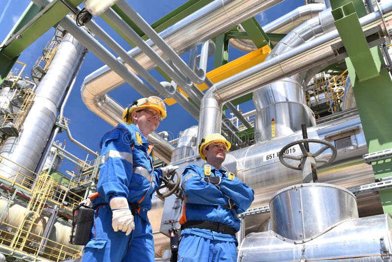 Arbeitnehmer in der chemischen Industrie Betriebsin der Arbeitskleidung in eine Raffinerie mit Rohre und Maschinen