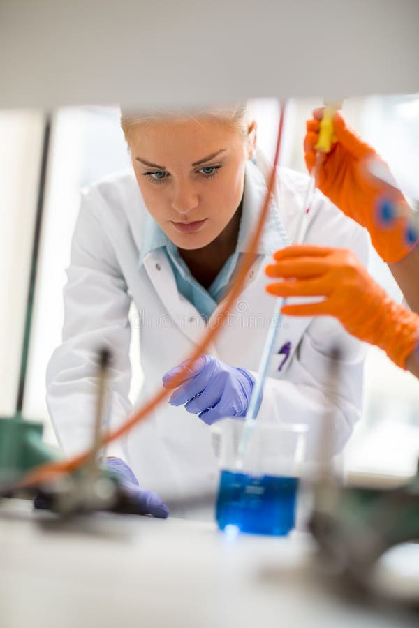 Arbeitnehmerin in der Labornehmenprobe der Flüssigkeit mit Pipette stockfotos Arbeitnehmerin in der Labornehmenprobe der Flüssigkeit mit Pipette stockfotos
