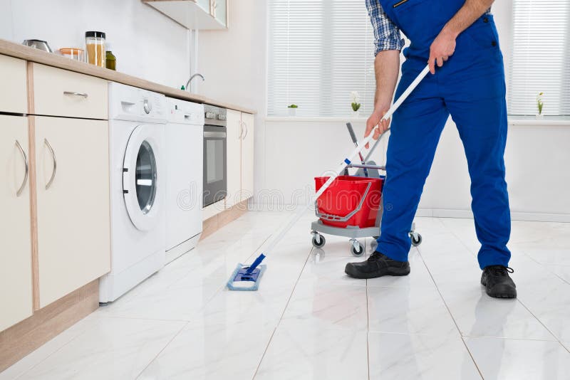 Arbeitskraft-Reinigungs-Boden im Küchen-Raum lizenzfreies stockfoto Arbeitskraft-Reinigungs-Boden im Küchen-Raum lizenzfreies stockfoto