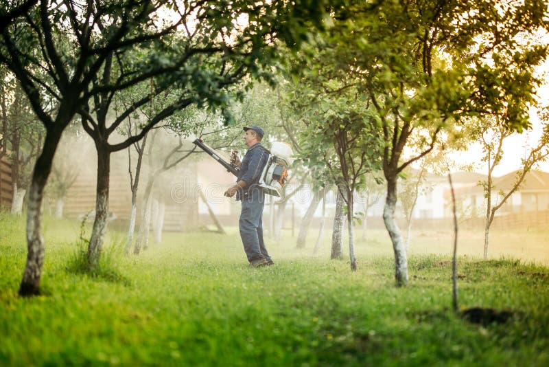 Arbeitskraft und Landwirt, der Spritzmaschine für Schädlingsbekämpfungsmittel und Insektenvertilgungsmittel verwendet stockbild Arbeitskraft und Landwirt, der Spritzmaschine für Schädlingsbekämpfungsmittel und Insektenvertilgungsmittel verwendet stockbild