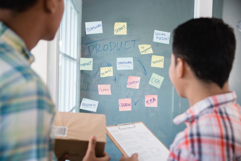 Arbeitskräfte des jungen Mannes, die zu den Papieranmerkungen betrachten, um einige Ideen zu finden, den Bürozielverkauf zu erhöh lizenzfreie stockfotografie