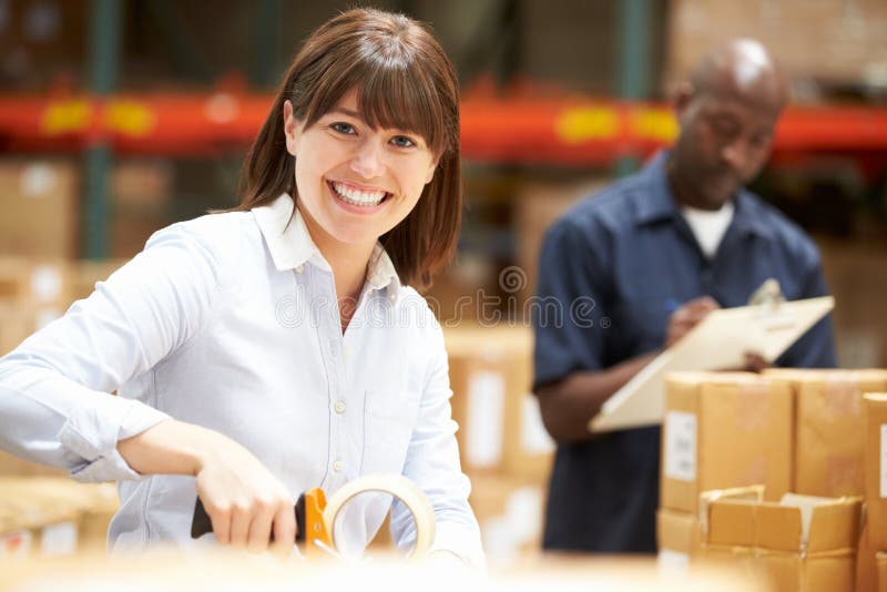 Arbeitskräfte im Lager, das Waren für Versand vorbereitet stockfoto Arbeitskräfte im Lager, das Waren für Versand vorbereitet stockfoto