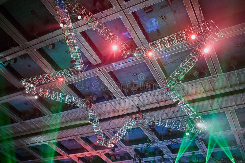 Working light devices and beams of color lights at construction in shape of star on ceiling during party. Working light devices and beams of color lights at construction in shape of star on ceiling during party