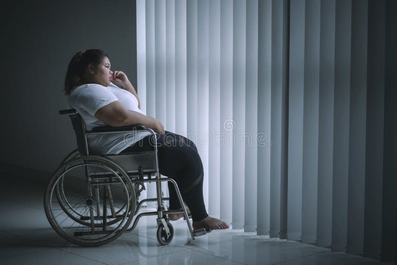 Arbeitsunfähige fette Frau schaut nahe dem Fenster nachdenklich stockfoto Arbeitsunfähige fette Frau schaut nahe dem Fenster nachdenklich stockfoto
