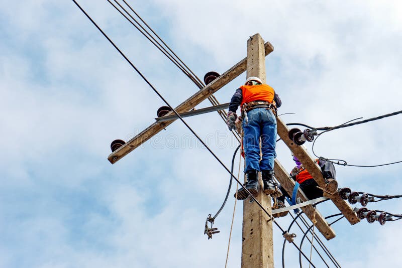 Arbetare för elektrikerlinjearbetarerepairman på klättringarbete på elektrisk stolpemaktpol royaltyfri fotografi