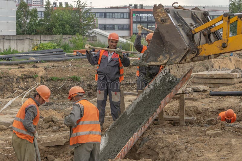 Arbetare på betonggrunden för konstruktionsplats royaltyfri bild Arbetare på betonggrunden för konstruktionsplats royaltyfri bild