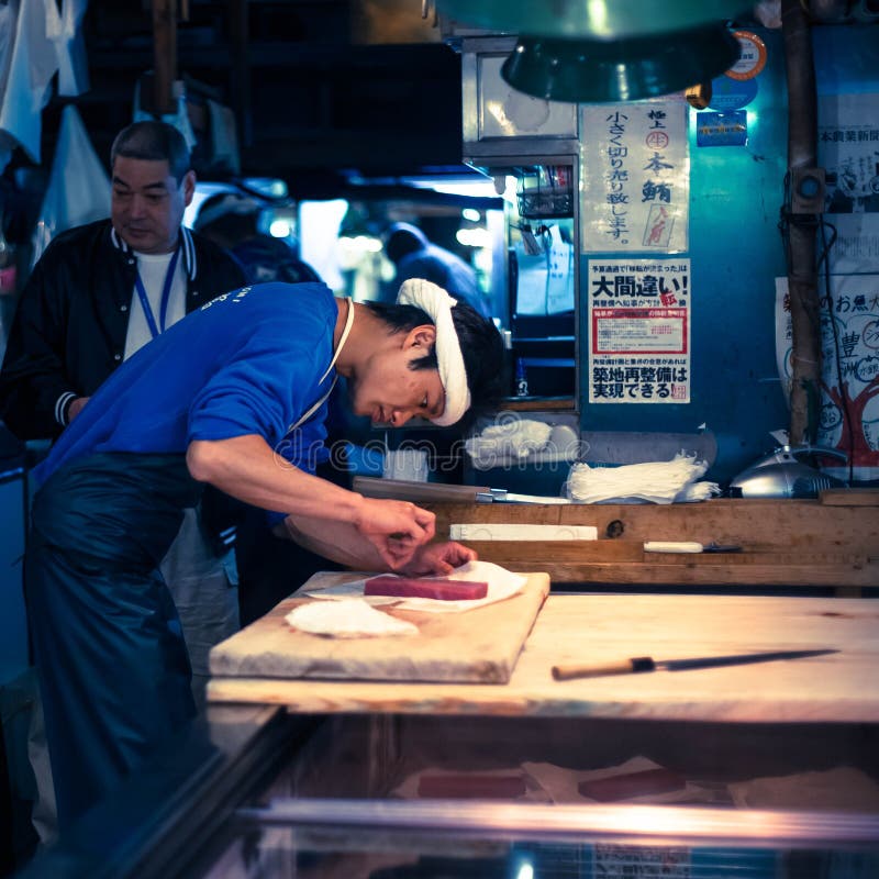 Arbetare som behandlar tonfisk på den Tsukiji marknaden i Japan royaltyfri fotografi Arbetare som behandlar tonfisk på den Tsukiji marknaden i Japan royaltyfri fotografi