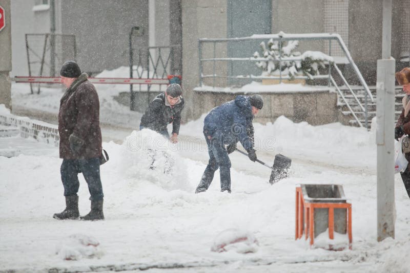 Arbetare som gör ren trottoaren i tung häftig snöstorm royaltyfri foto Arbetare som gör ren trottoaren i tung häftig snöstorm royaltyfri foto
