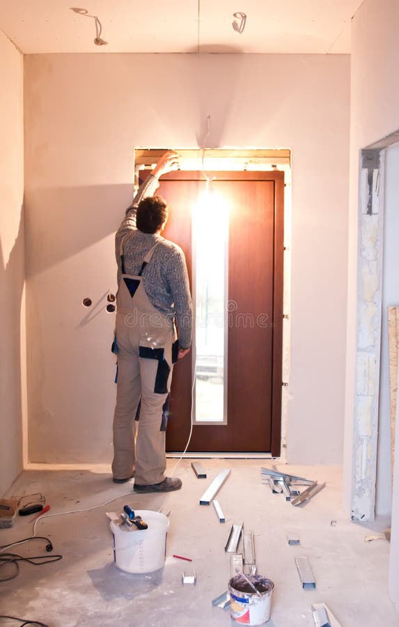 Arbetare som installerar den nya dörren royaltyfria bilder Arbetare som installerar den nya dörren royaltyfria bilder