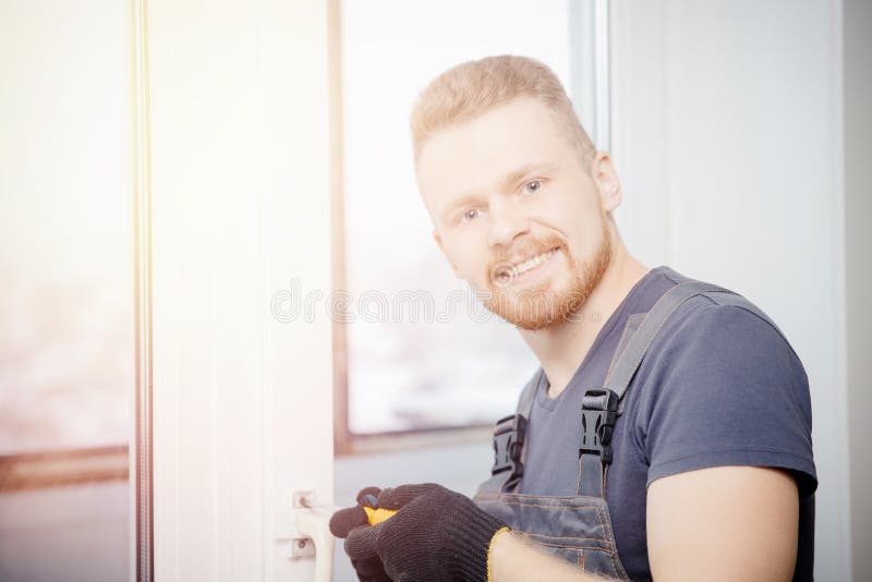 Arbetarmannen installerar plast- fönster och dörrar med dubblett-glasad vit royaltyfri foto Arbetarmannen installerar plast- fönster och dörrar med dubblett-glasad vit royaltyfri foto