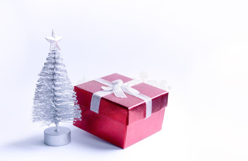 Arbre et boîte-cadeau de Noël décoratifs sur le fond pelucheux de neige images stock Arbre et boîte-cadeau de Noël décoratifs sur le fond pelucheux de neige images stock