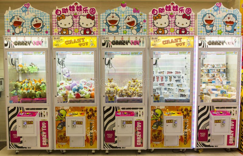 Robotic claw game machine in arcade. Claw crane is type of arcade game known as merchandiser, commonly found in video arcade, supermarket, shopping mall, and bowling alley. Claw vending machine consists of prizes, usually plush toys. Player inserts coins into machine, which then allows player to manipulate joystick that controls claw for variable time. Claw machine stock images, royalty-free photos and pictures