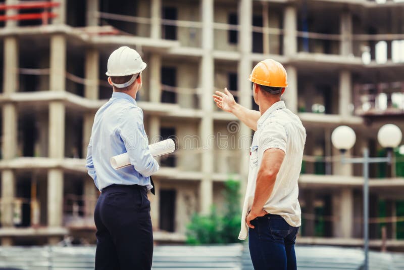 Architect and builder discussing at construction site royalty free stock images