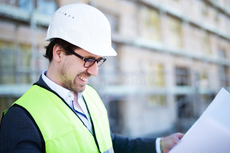 An Architect / Civil Engineer at Work on a Construction Site, Holding