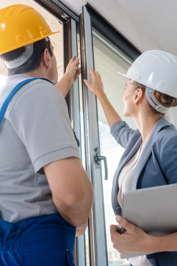 Architect and construction worker checking windows on site stock photos