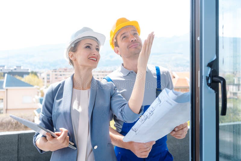 Architect and construction worker checking windows on site stock photography