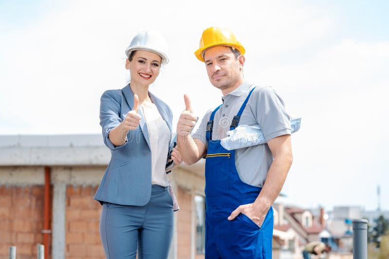 Architect and Construction worker on site giving thumbs-up royalty free stock photo