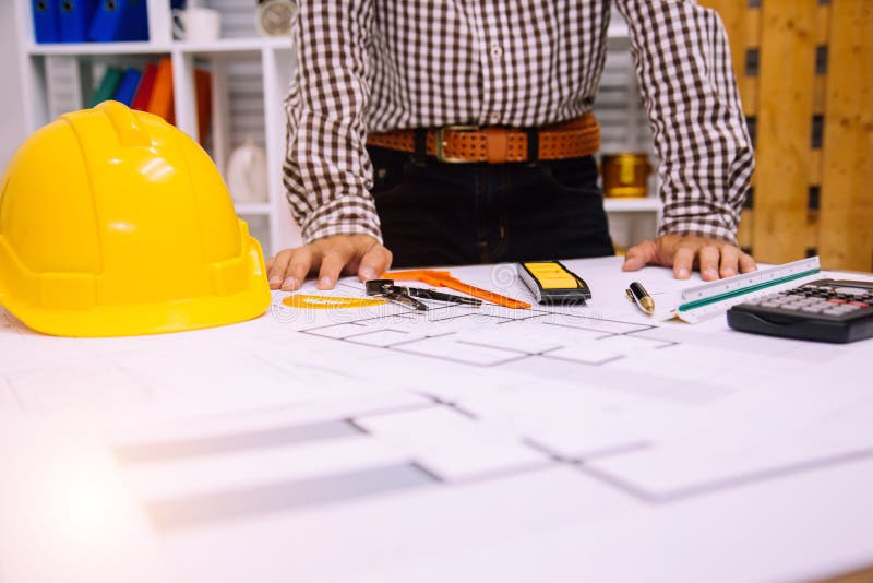 Engineer Man and Architect Drawings Blueprint at Construction Site.Home