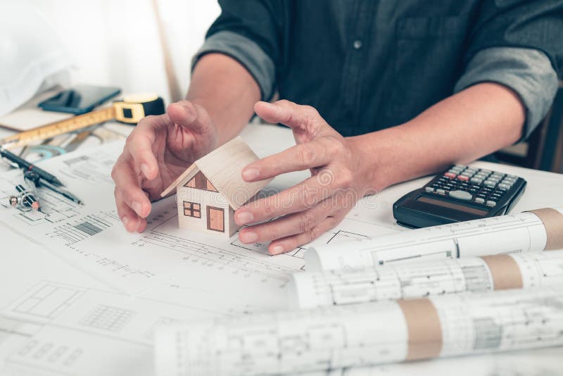 Architect Engineer Hands Hold and Protect Mini House Model on Blueprint. Protect House, Cost