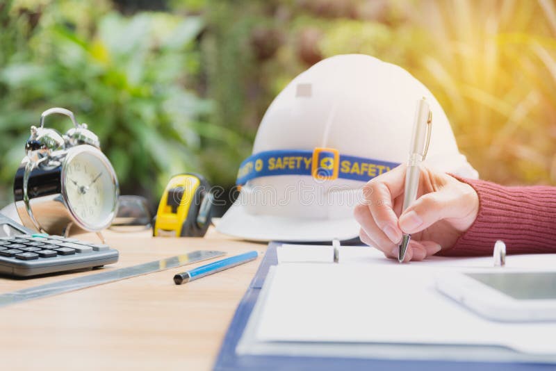 Architect engineer working concept with helmet, alarm clock.