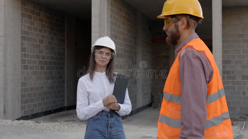 Construction workers inspecting building site progress, architect and foreman discussing project stock video