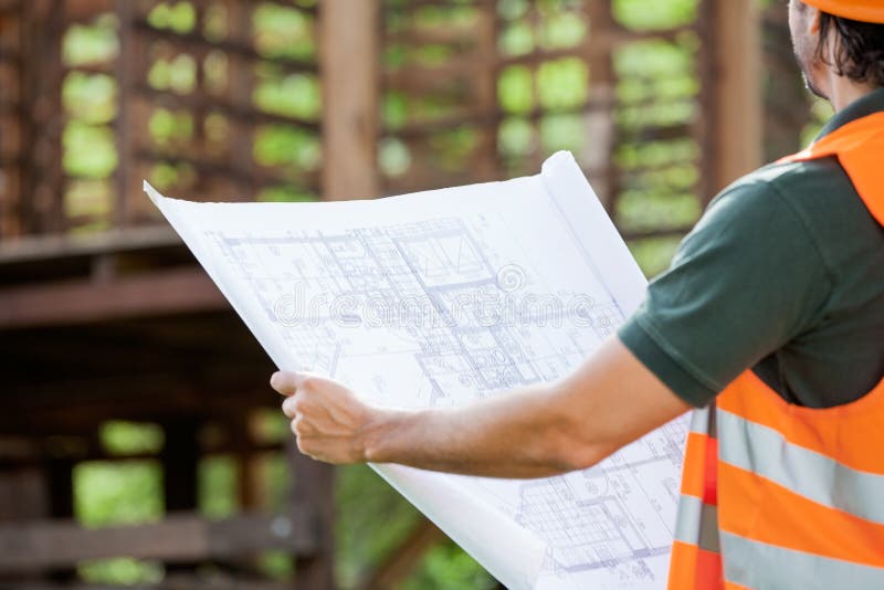 Architect Holding Blueprint At Construction Site stock images Architect Holding Blueprint At Construction Site stock images