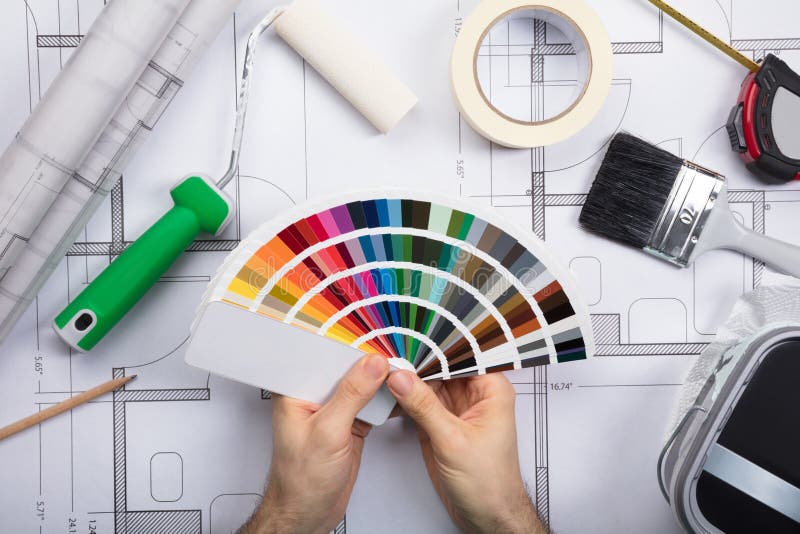 An Architect Holding Color Guide Swatch On Blueprints