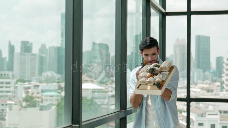 Architect lift house model to check mistake point with skyscraper. Tracery