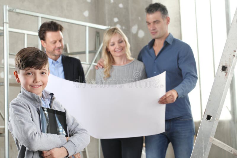 Architect showing house design plans to a family with smiling happy child with digital tablet. House building goal concept. stock image