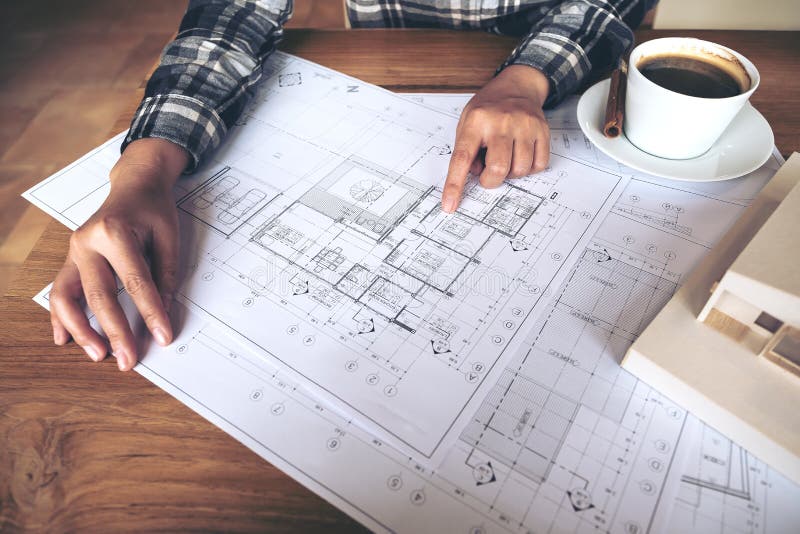 Architect working on an architecture model with shop drawing paper and coffee cup on table royalty free stock image Architect working on an architecture model with shop drawing paper and coffee cup on table royalty free stock image