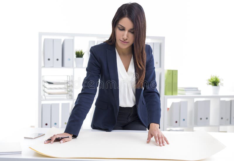 Architecte centré de femme travaillant avec des modèles tout en se tenant image libre de droits Architecte centré de femme travaillant avec des modèles tout en se tenant image libre de droits