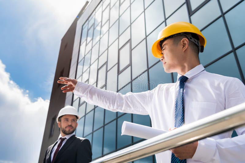 Architectes professionnels dans le tenue de soirée fonctionnant au bureau moderne images stock
