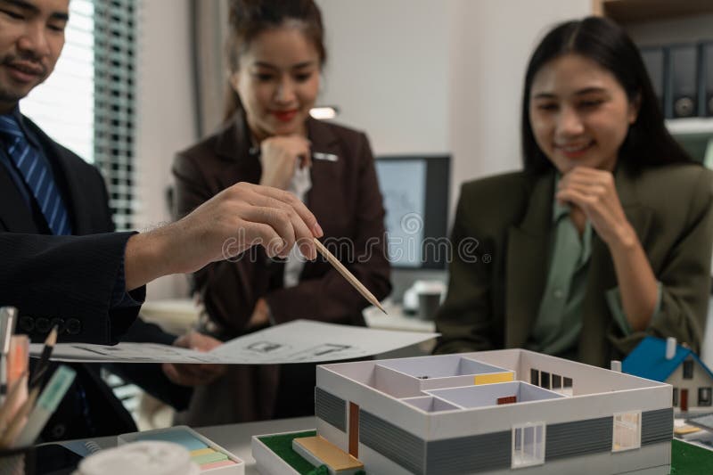 Architects work with engineers and contractors in the office to check the accuracy of the first draft plan, blueprint on the desk stock images