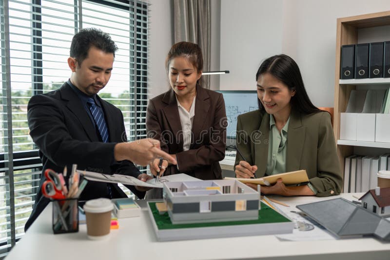 Architects work with engineers and contractors in the office to check the accuracy of the first draft plan, blueprint on the desk royalty free stock image