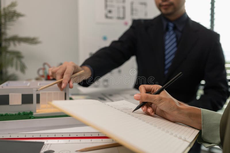 Architects work with engineers and contractors in the office to check the accuracy of the first draft plan, blueprint on the desk stock photos