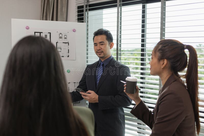 Architects work with engineers and contractors in the office to check the accuracy of the first draft plan, blueprint on the desk stock images