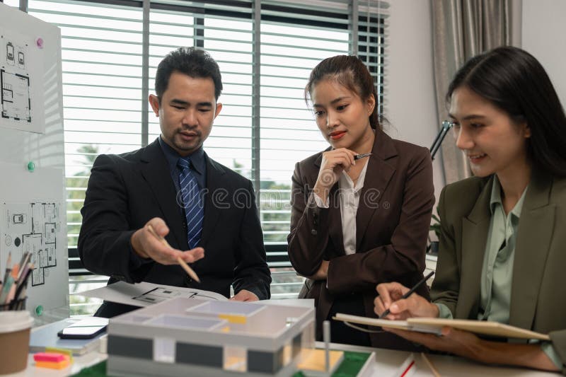 Architects work with engineers and contractors in the office to check the accuracy of the first draft plan, blueprint on the desk royalty free stock photos