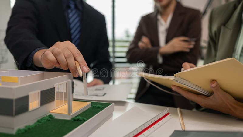 Architects work with engineers and contractors in the office to check the accuracy of the first draft plan, blueprint on the desk stock image