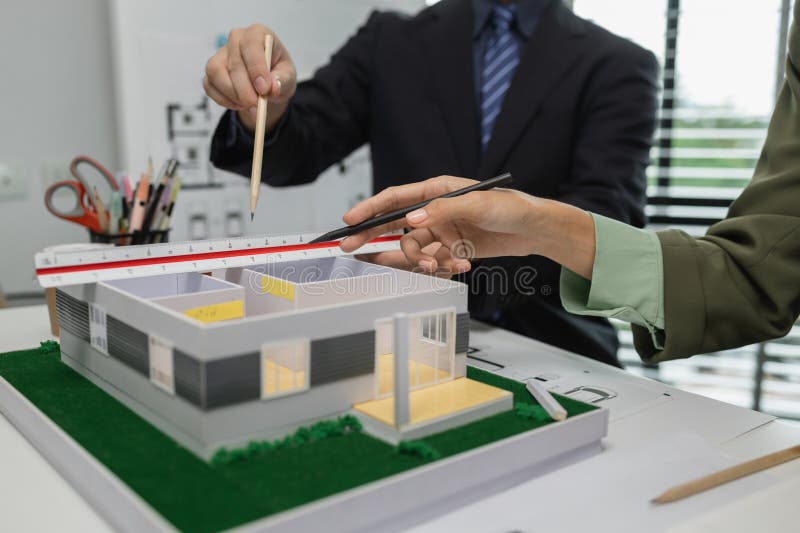 Architects work with engineers and contractors in the office to check the accuracy of the first draft plan, blueprint on the desk royalty free stock photo