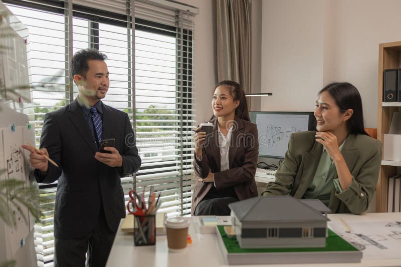 Architects work with engineers and contractors in the office to check the accuracy of the first draft plan, blueprint on the desk royalty free stock photo