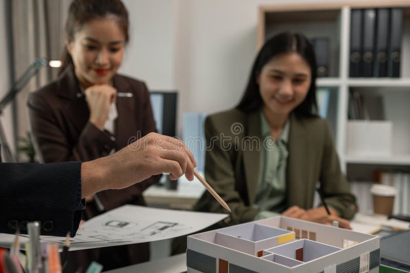 Architects work with engineers and contractors in the office to check the accuracy of the first draft plan, blueprint on the desk stock photo