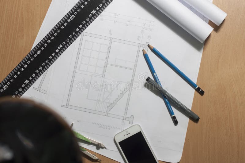 Architectural blueprints and blueprint rolls and a drawing instruments royalty free stock photography