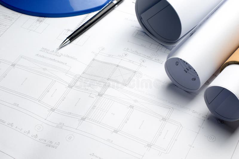 Architectural blueprints and blueprint rolls and a drawing instruments on the worktable royalty free stock images