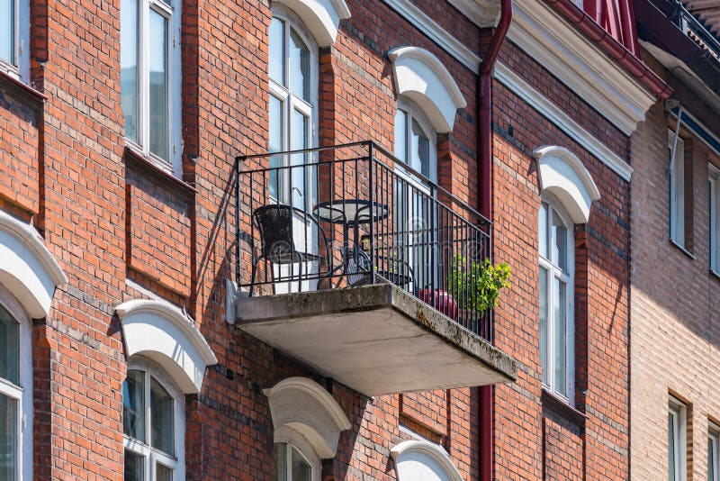 Architectural details of modern apartment building. Balcony with chairs and flowers