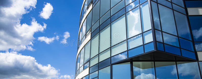 Architecture exterior facade building glass windows wall design panoramic urban landmark city view on vivid blue sky white clouds