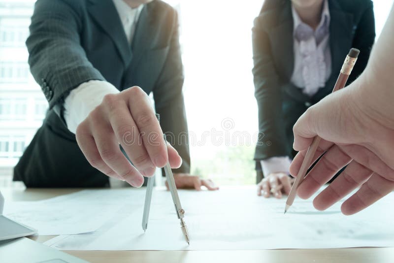 Architectuurteam die aan blauwdruk werken stock afbeeldingen Architectuurteam die aan blauwdruk werken stock afbeeldingen