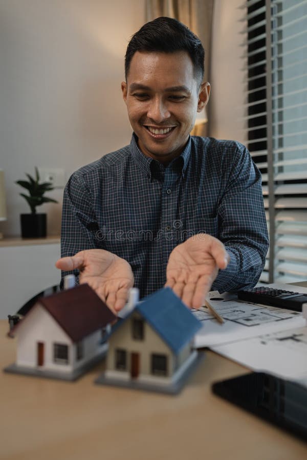Architekten zeichnen und gestalten Hausunternehmer oder Architekten mit dem Modell eines Hauses, das in einem Architektenportrait stockfotografie